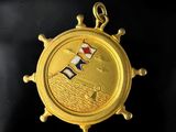 an image of a gold medal with a flag on it