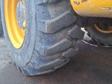 a close up of a yellow tractor tire on a street