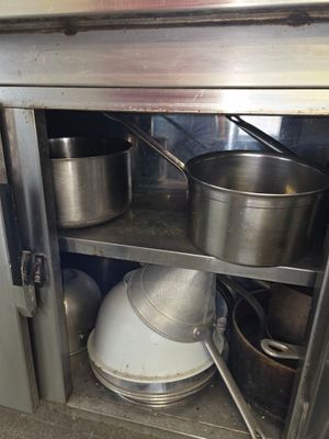 pots and pans sitting on a shelf in a kitchen