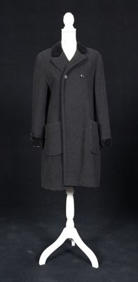une image d'un manteau noir sur un support de mannequin