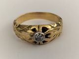 a close up of a gold ring with a diamond in the center