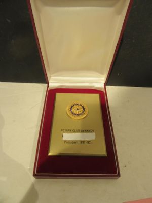 a gold medal in a red box on a white table