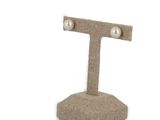 a pair of pearl earrings on a stand on a white background