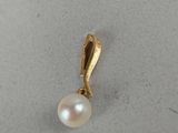 a close up of a pearl pendant on a white surface
