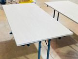 trois tables au milieu d'une pièce, avec des canapés en arrière-plan