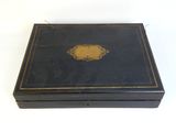 an old black box with a gold medallion on the lid