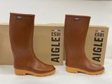 deux paires de bottes de pluie marron posées sur une boîte en carton