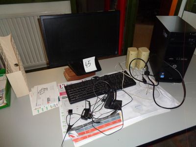 un bureau sur lequel se trouvent un ordinateur, un clavier, une souris et d'autres objets