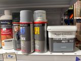 many different types of paint on a shelf in a store