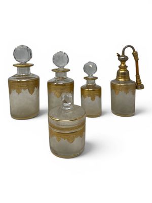 four glass bottles with gold and silver designs on them