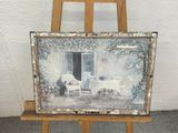 a picture of a painting on a easel next to a chair