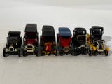 several toy cars are lined up in a row on a white surface