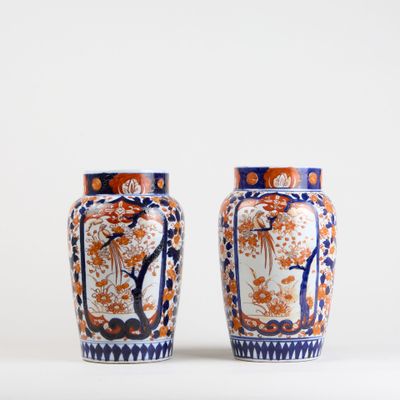 pair of orange and blue vases sitting on a white surface