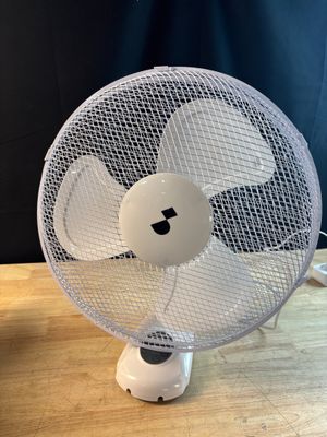 a white fan sitting on top of a wooden table