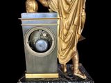 a statue of a man holding a globe on a stand