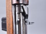 a close up of a gun with a wooden handle on a gray background