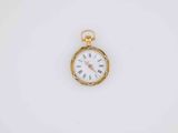 a close up of a gold pocket watch on a white surface