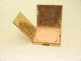 a small gold compact case with a mirror in it