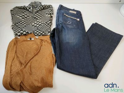 two pairs of jeans and a sweater are sitting on a table