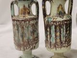 three vases sitting next to each other on a white surface