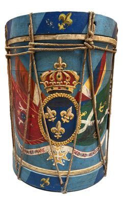 a drum with a crown on it and a flag on the side