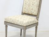 a chair with a floral upholstered back and a wooden frame