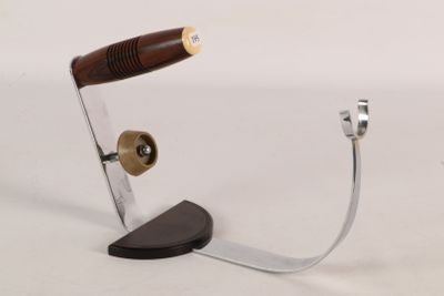 a metal object with a wooden handle on a white surface