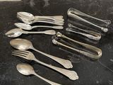 beaucoup de cuillères en argent et de cuillères à soupe sur une table