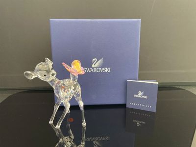 La figurine est posée sur la table, à côté de la boîte.