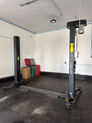an image of a garage with a lift in the middle of the room