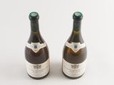 two bottles of wine sitting next to each other on a white surface