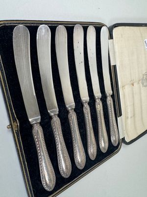 a case with six knives in it on a table