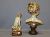 a statue of a woman sitting on a pedestal next to a statue of a man