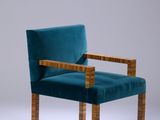 an upholstered chair with a wooden frame and blue velvet upholstered seat