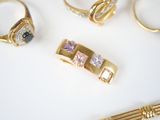 five different rings and a tie bar on a table