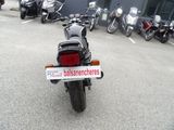 several motorcycles parked in a parking lot with a sign on the back of the bike
