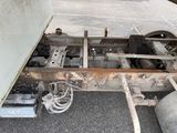 underside of a semi truck with a flat bed and a flat tire