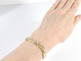 someone is wearing a gold bracelet with the word love written on it