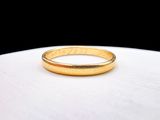 an image of a gold wedding ring on a white surface