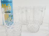 four glasses and a can of soda sitting on a table
