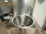 a stainless steel sink in the corner of a kitchen