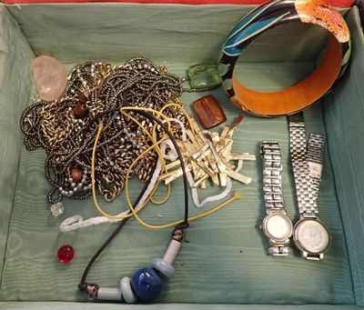 une boîte en bois contenant divers objets, notamment une montre, des bracelets et d'autres articles