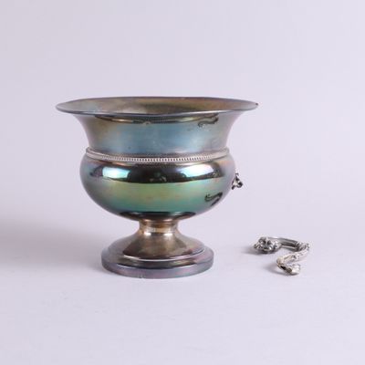 un vase en argent orné d'un anneau, à côté d'une paire de boucles d'oreilles