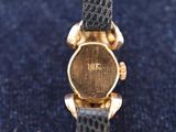 an image of a close up of a wrist watch on a blue surface