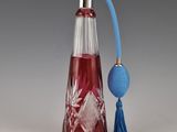 une bouteille en verre rouge avec une poignée bleue et une boule bleue