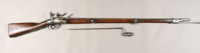 un vieux pistolet avec une crosse en bois et une poignée en métal