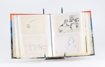 un livre ouvert, orné de dessins, posé sur une surface blanche