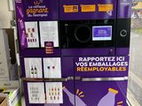 a purple vending machine in a store with a sign on it