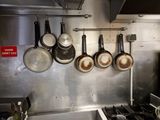 pots and pans hanging on the wall in the kitchen