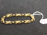 a close up of a gold bracelet with a tag on it